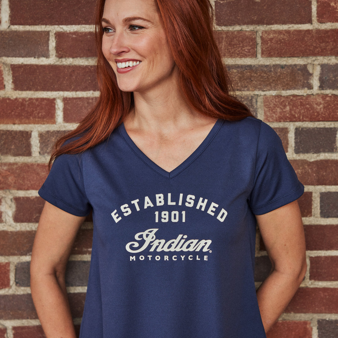 Women in an Indian Motorcycle t-shirt standing in front of a brick wall