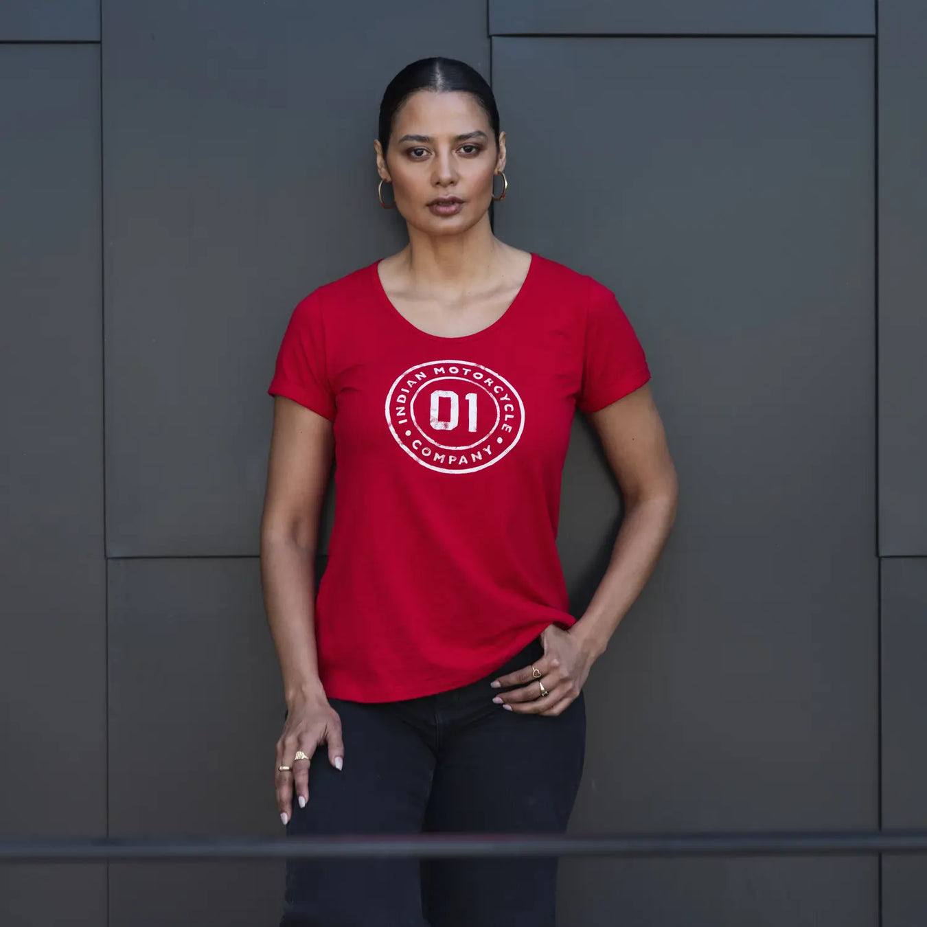 Women in an Indian Motorcycle t-shirt standing in front of a brick wall