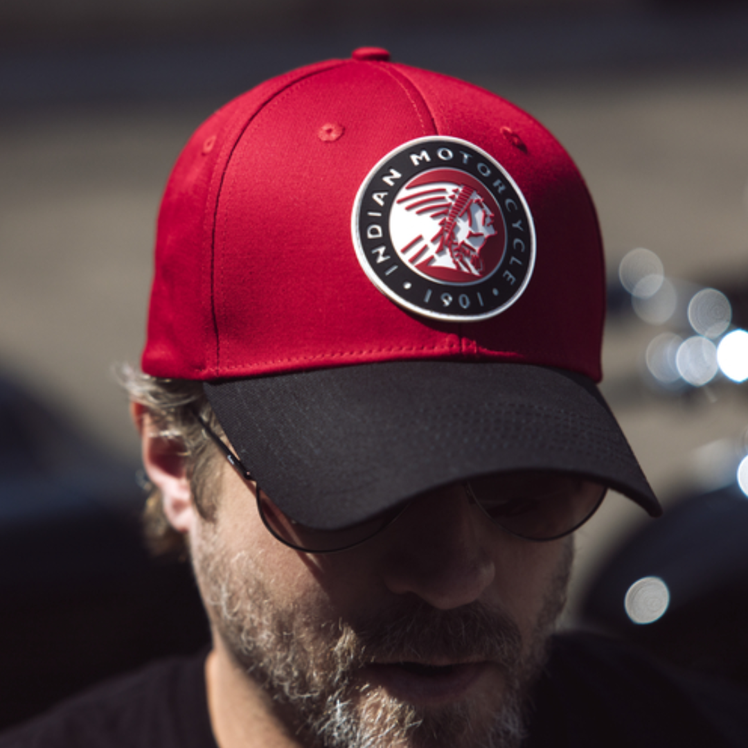 Man wearing sunglasses and a white and black Indian Motorcycle hat