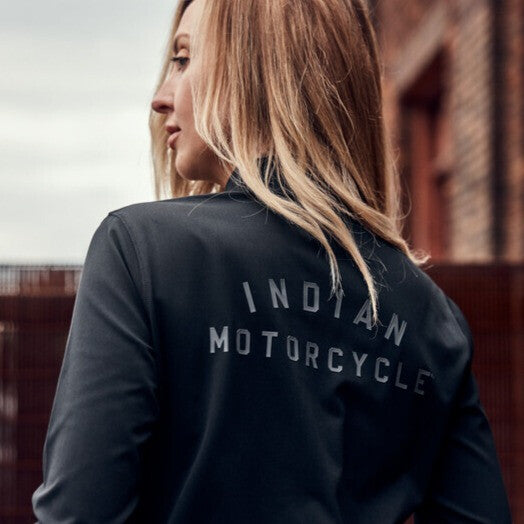 Women in an Indian Motorcycle t-shirt standing in front of a brick wall